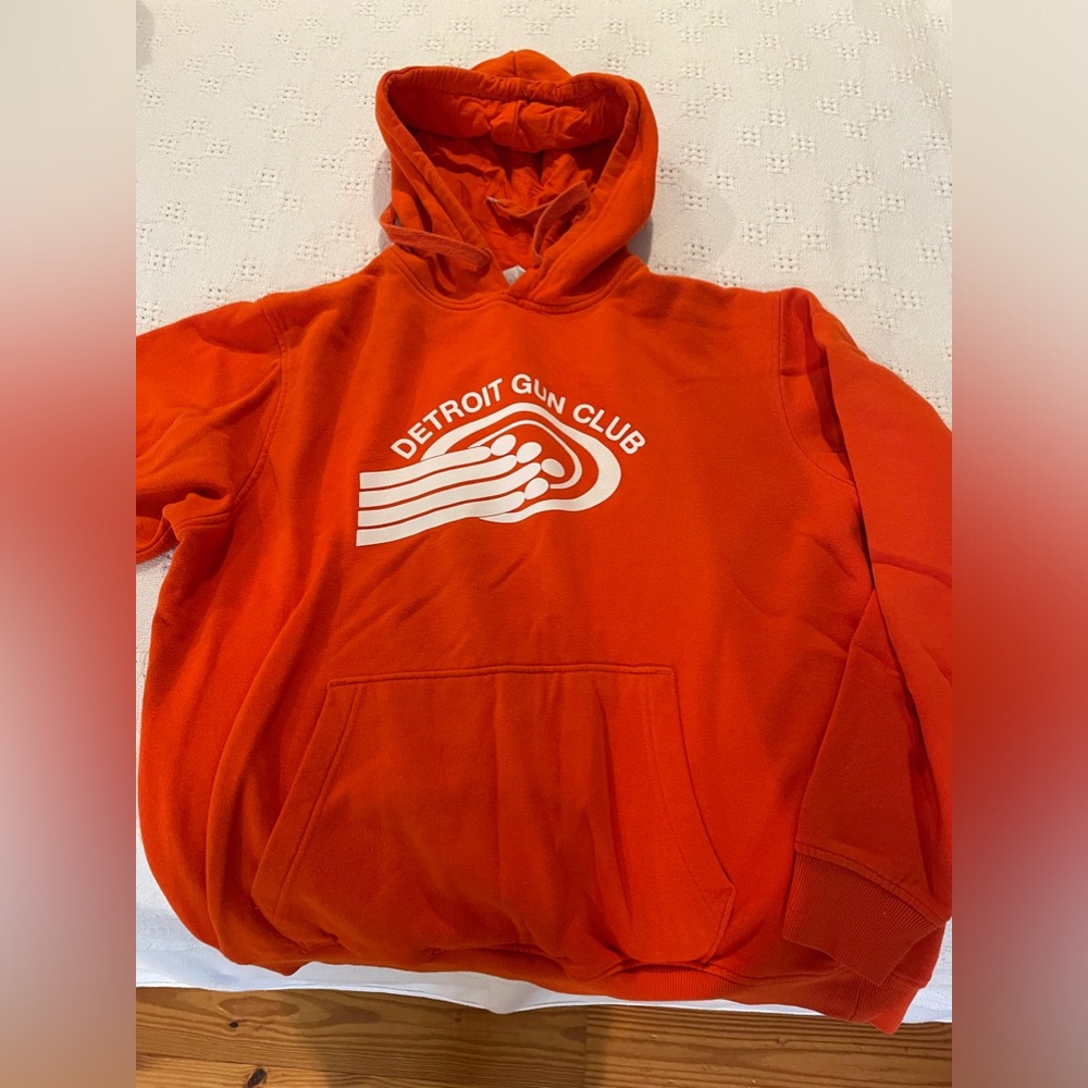 Bright Orange Detroit Gun Club sweatshirt.